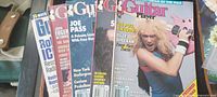 Stack of five Guitar Player magazines showing covers of David Lee Roth, Steve Vai, Joe Pass, John Fogerty and a fifth partially visible issue