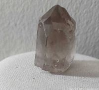 Front view of the smokey quartz point standing upright