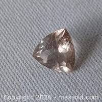 Trillion-cut gemstone on fabric background