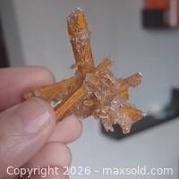 Front view of golden-brown gypsum cluster held in hand