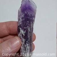 Amethyst point held in hand showing size and colour gradient