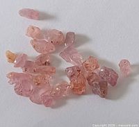 Loose rough pink spinel stones grouped on white background