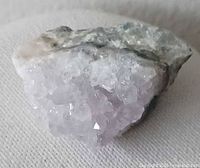 Front view of pale purple amethyst cluster on matrix