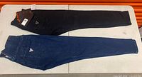 Both pairs of jeans laid flat, black and blue