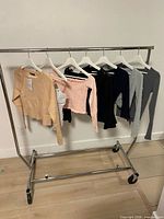 Overview of seven tops on clothing rack