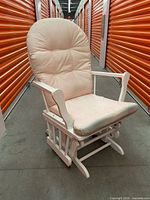 Front view of white wood glider chair with pink cushions