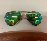 Front view of Ray-Ban aviator sunglasses showing green mirror lenses and gold frame
