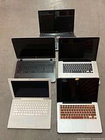 Group shot of six laptops arranged on the floor