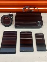 All five items laid out: Blu-ray player, wireless charger, two tablets, smartphone