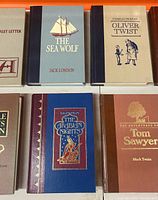 Six hardback books including The Sea Wolf, Oliver Twist, Arabian Nights, Tom Sawyer