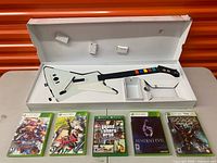 Top view of X-Plorer guitar controller in box with five game cases