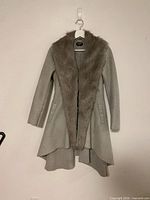 Full view of grey Bebe coat showing faux-fur collar, asymmetrical hem and pockets