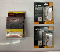 Overall lot showing CURT wiring harness and two NOMA adapters in packaging