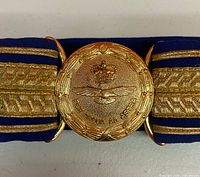 Close-up of gilt buckle showing crown, eagle and motto