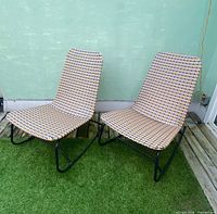 Pair of woven rattan lounge chairs on grass