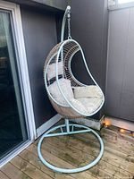 Full view of hanging egg chair showing stand, base and cushions