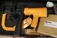 Yellow Bostitch flooring nailer with two orange foot attachments, mallet head in view and box of Bostitch flooring foot