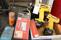 Two Dewalt cordless drills, two black battery chargers, and packaged drill bits and marking tool in a cardboard box.