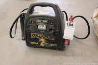 Front view of Motomaster Eliminator 700A mobile booster with attached cables and identification tag.