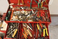 Full view of red Mastercraft toolbox top tray and three drawers containing assorted tools and hardware components including pliers, screwdrivers, scissors, and other small tools.