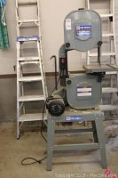 Full view of bandsaw on stand with power cord