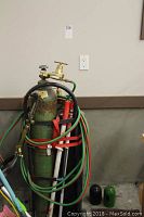 Full view of both gas cylinders on steel cart with hoses and torch
