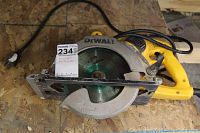 Full view of yellow and metal DeWalt circular saw with attached electric cord and visible rust and wear on blade and housing.