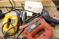 Two electric jigsaws and Jobmate drill on wooden surface showing cords and normal wear.