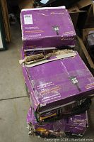 Four stacked boxes of purple Malibu branded packaging for high power LED landscape garden lights with some boxes visibly damaged.
