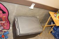 Closed rectangular electric cooler by Coleman with molded lid and power cord visible.