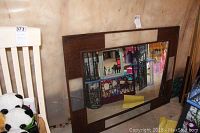 Mirror leaning against a wall, showing full size and metal frame with rivet details.