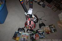 Assorted Xbox 360 games including Halo 3, Monopoly, Call of Duty, LEGO Batman, Full Auto, and Tom Clancy's Splinter Cell with two Xbox 360 wireless controllers and two Guitar Hero game controllers.