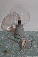 Full view showing bubble glass mushroom shade, concrete base and clear cord