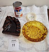 Group shot showing three ashtrays with soup can for scale