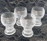 Four clear textured Iittala Kekkerit goblets front view