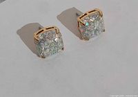 Front view of both square glitter stud earrings in gold-tone settings