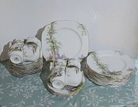 Overview of stacked plates and cups showing Greenwood Tree pattern