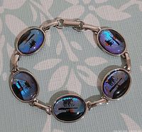 Front view of bracelet showing six iridescent butterfly wing cabochons