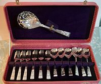 Entire open case showing serving spoon, six dessert spoons, six dessert forks in velvet lining