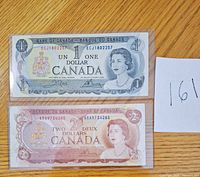 Fronts of $1 and $2 Canadian banknotes in sleeves