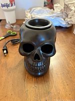 Front view of black skull wax warmer showing top dish and power cord