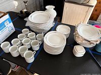 Full set spread on table including plates, bowls, cups and sugar bowl