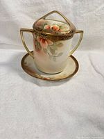 Pitcher with lid on saucer showing floral design and gold trim