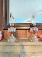 Both clear glass oil lamps side by side showing overall form and size.