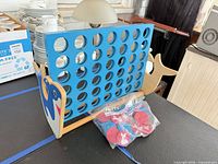 Full view of wooden shark Connect Four game with bag of discs