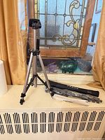 Tripod standing extended next to packaged monopod