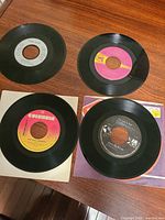 Four 7" singles laid out showing labels and partial sleeves