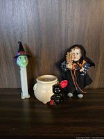 Group view of doll, PEZ dispenser, cauldron, cat