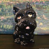 Front view showing glossy black ceramic dog planter and painted facial details