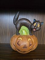 Front view of resin jack-o-lantern with black cat figurine